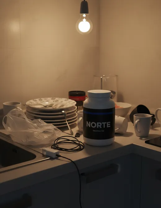 El mismo frasco en una cocina desordenada, con poca luz